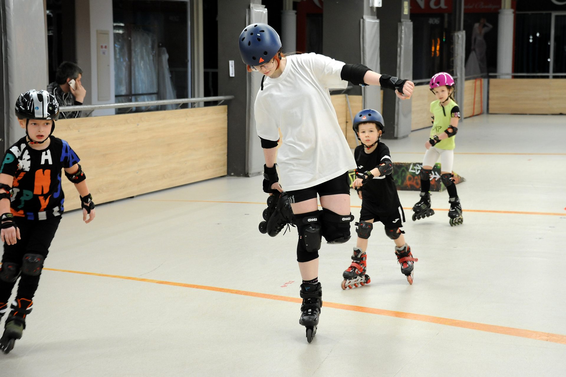 Copii cu căști și protecții patinând pe role în Roller Park Chișinău